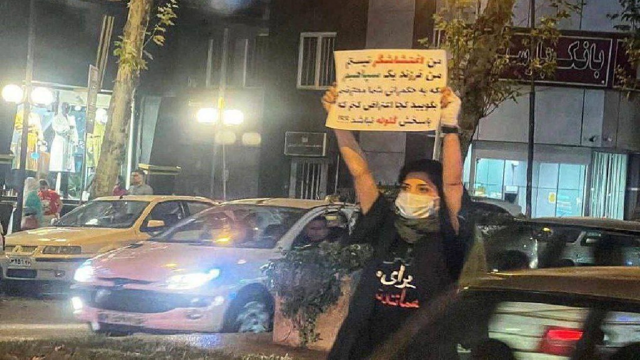 ابنة عضو في الحرس الثوري الإيراني تحمل لافتة وتحتج ضد النظام