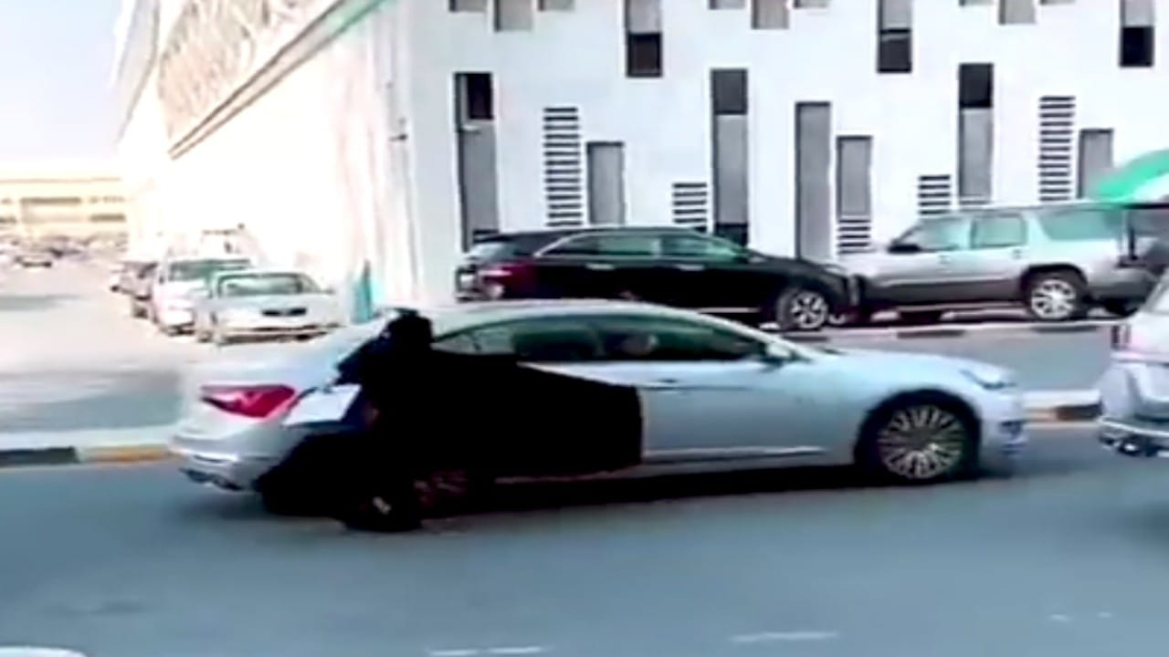 بالفيديو.. سيدة تتعرض للسقوط بعدما تعلقت عباءاتها بباب المركبة