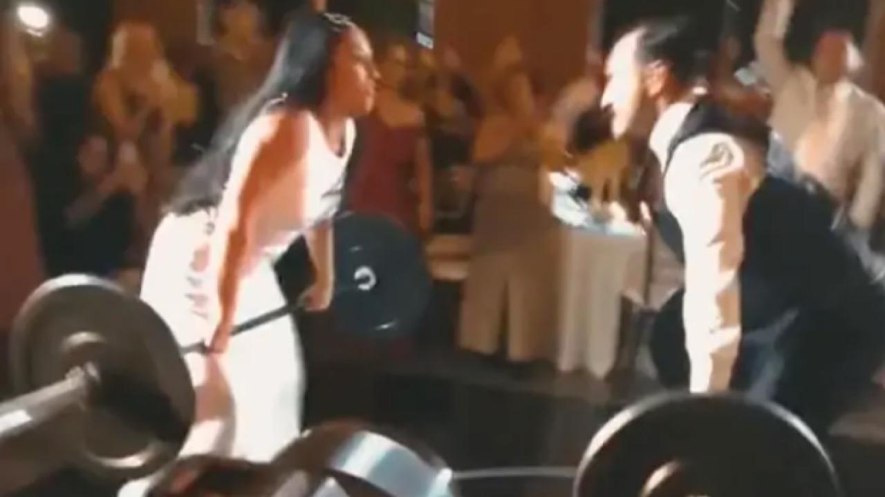 بالفيديو.. عروس تتحدى زوجها برفع الأثقال خلال حفل زفافهما