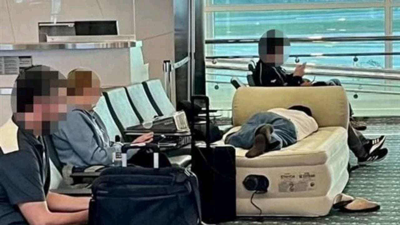مسافر ينام على سرير هوائي داخل مطار بعدما تأخرت رحلته