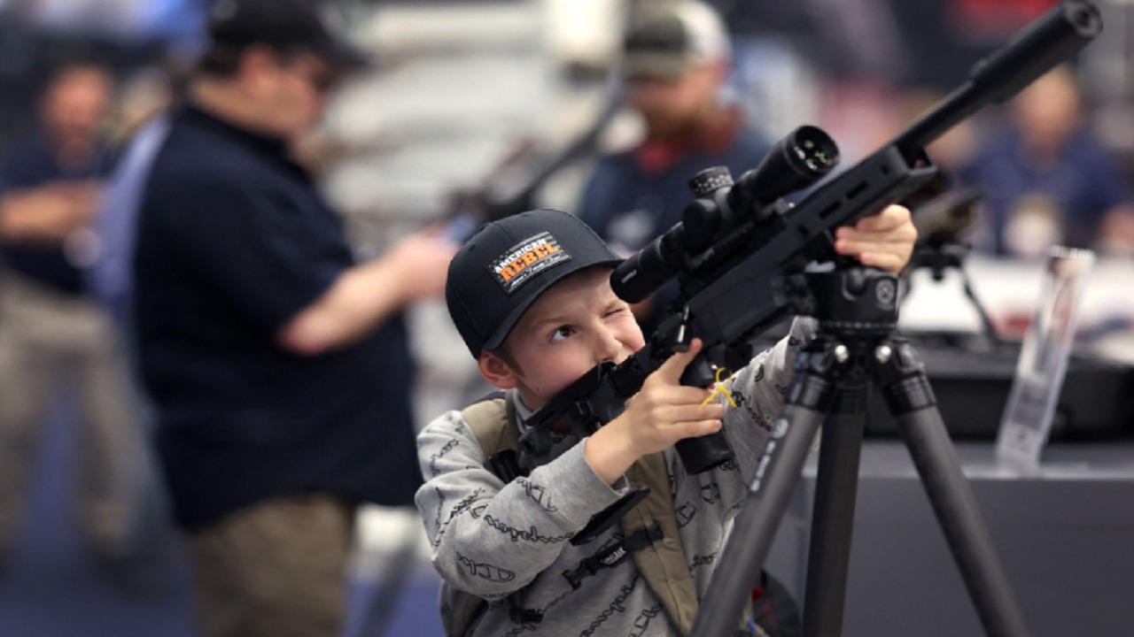 بالصور.. أطفال يجربون استخدام الأسلحة خلال معرض بأمريكا
