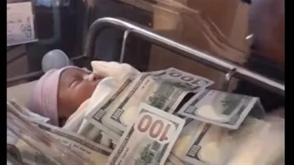 بالفيديو.. أب يغطي طفله بمئات الدولارات فور ولادته