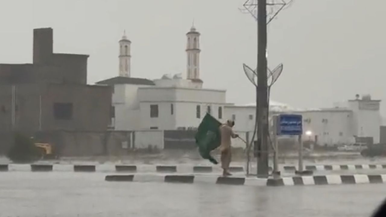 مشهد رائع لعامل باكستاني يرفع علم المملكة بعد وقوعه وسط الأمطار الغزيرة