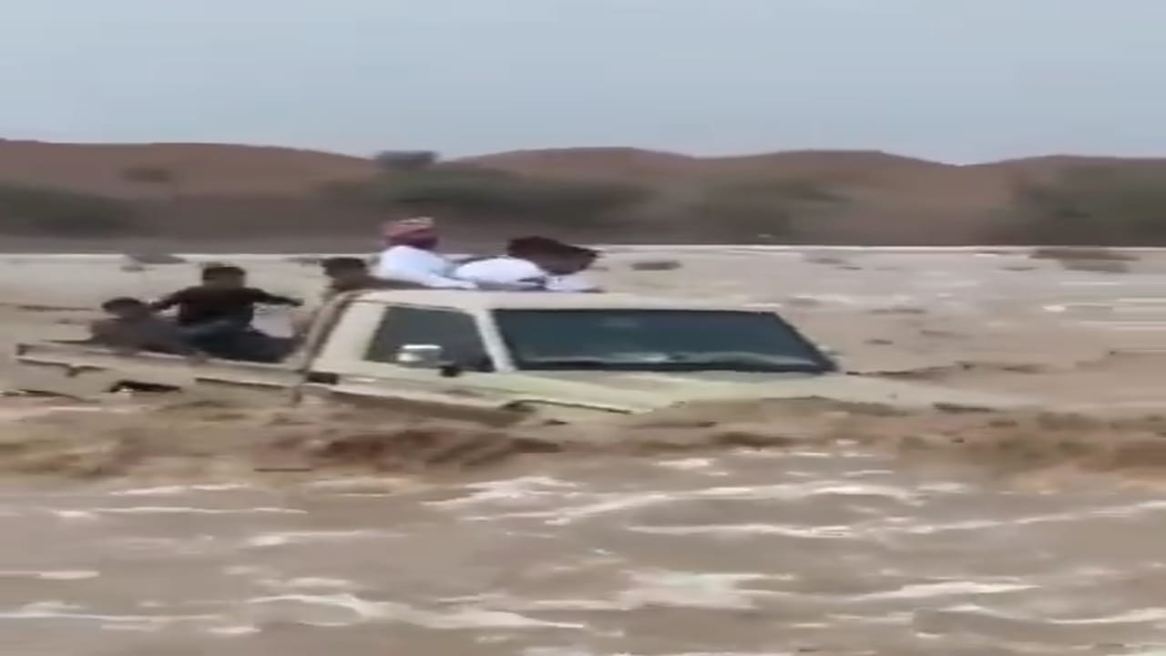 سائق يغامر بحياة أولاده ويقطع السيل بسيارته.. فيديو