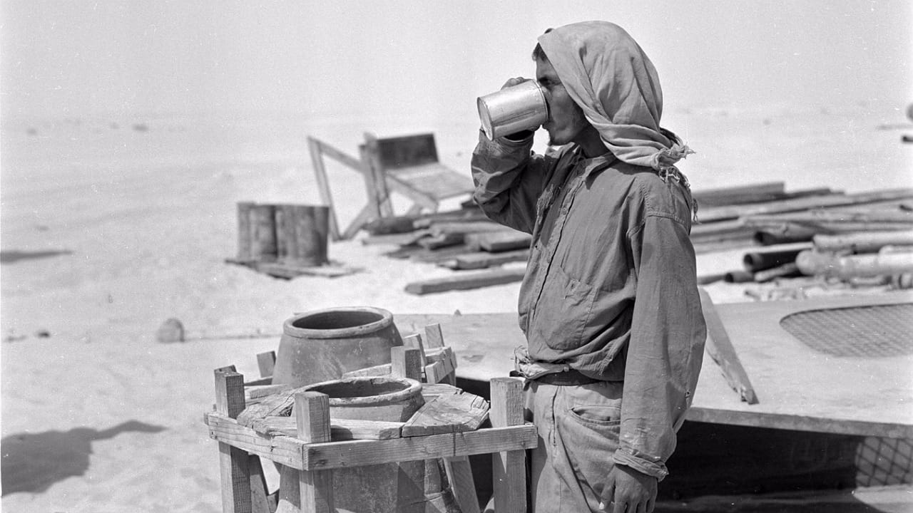 عامل يشرب من زير ماء فخاري في الأحساء قبل 76 عاماً.. صورة