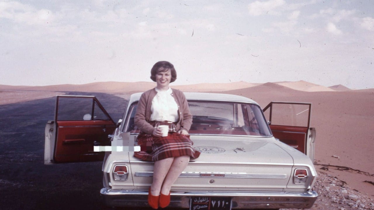 سيدة تلتقط صورة مع الكثبان الرملية في أحد طرق الشرقية قبل 60 عامًا