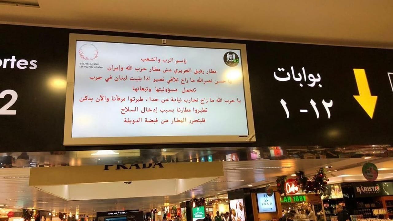 اختراق شاشات مطار بيروت وعرض رسالة تحذيرية إلى حزب الله .. فيديو