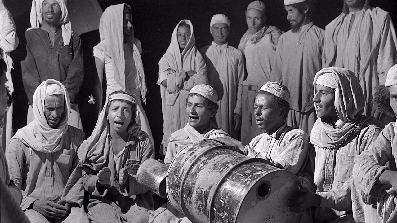 صورة نادرة لعمال بحرينيين يستخدمون البراميل كأدوات موسيقية
