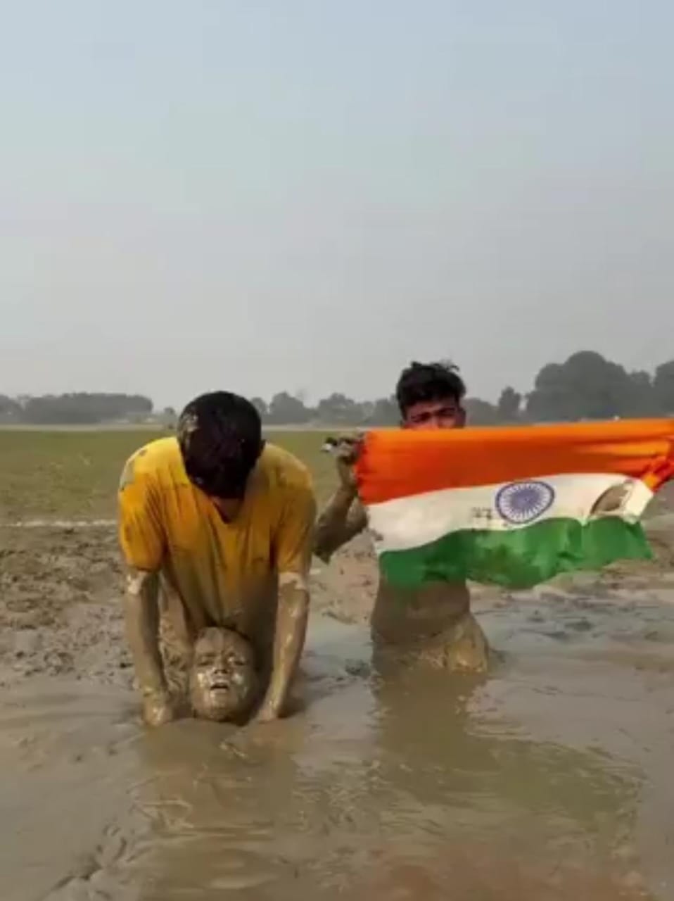 هنود يدفنون أنفسهم مع العلم الهندي في الطين لكسب المال.. فيديو