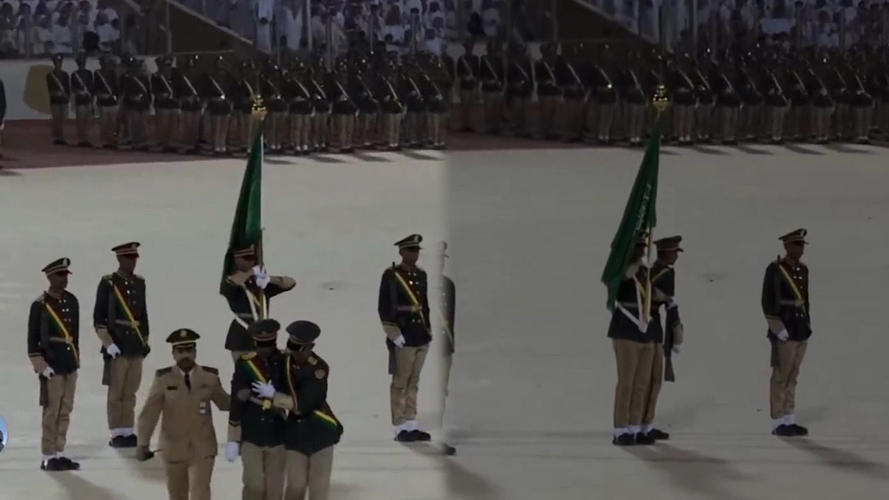 طالب يرفع الراية بيد وبالأخرى يسند زميله المغمى عليه خلال حفل تخريج كلية الملك عبد العزيز الحربية