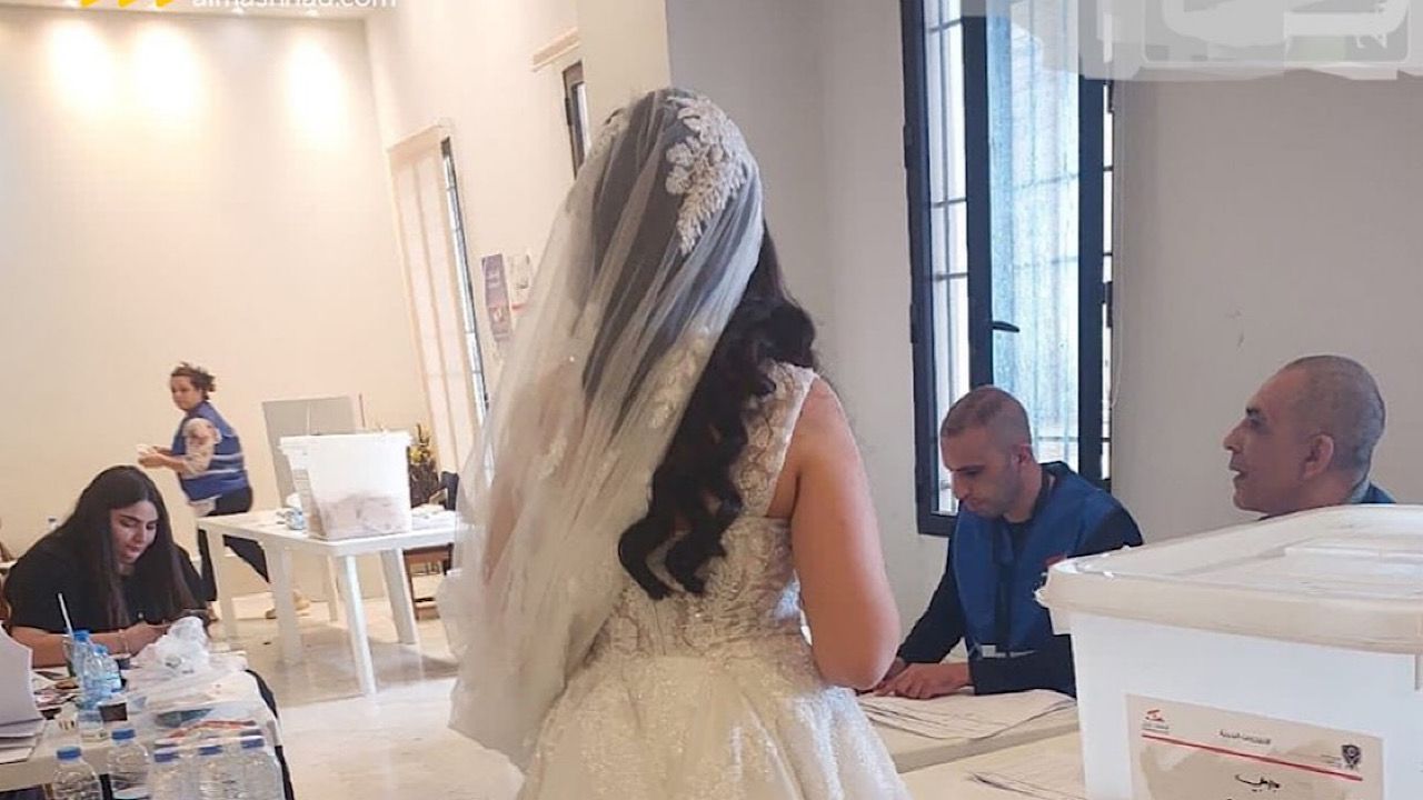 عروس بفستان الزفاف تدلي بصوتها داخل مركز اقتراع