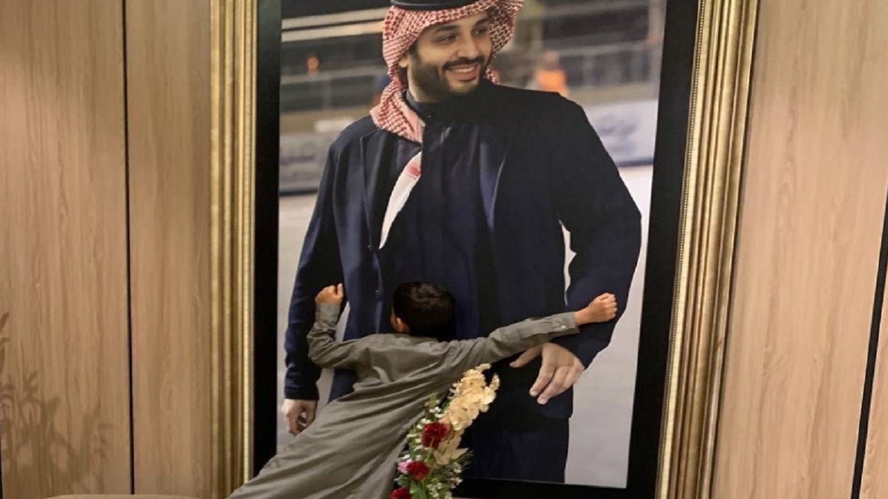 لقطة عفوية لطفل يحتضن صورة ولي العهد .. صورة