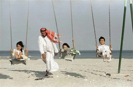 أب يلاعب أطفاله بجوار شاطئ  الخبر