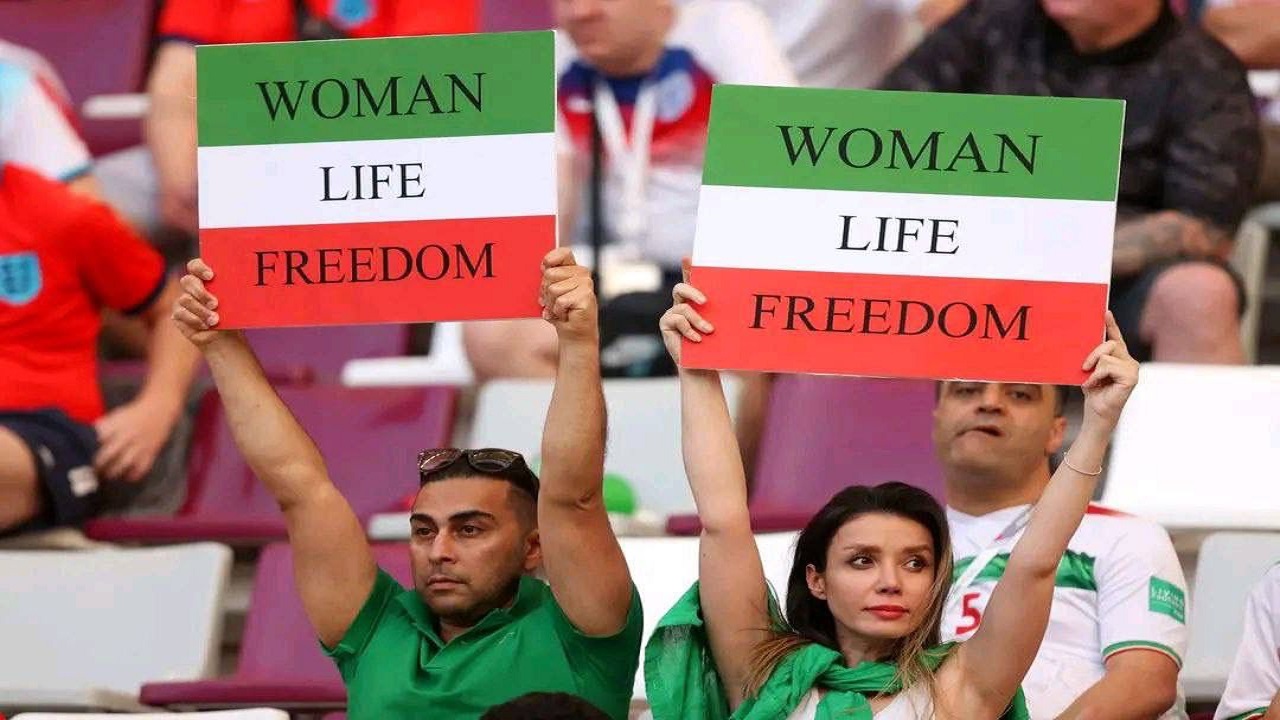 مشجعون إيرانيون يرفعون لافتات مناهضة للملالي