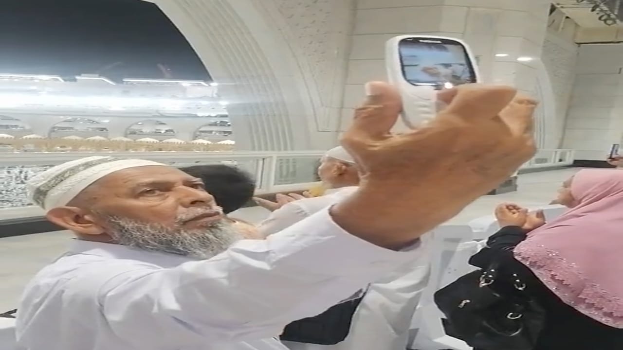 مسن يحاول التقاط صورة لنفسه في الحرم المكي بهاتف قديم .. فيديو